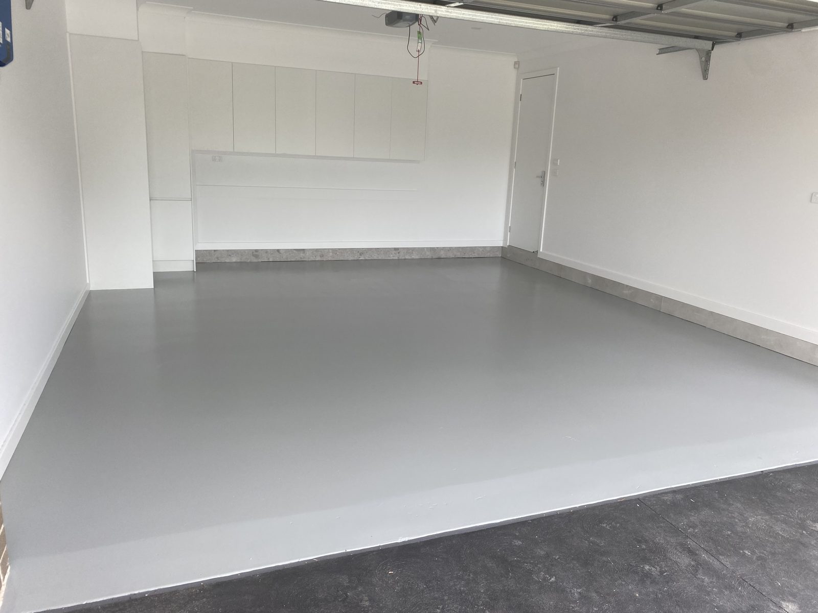 A garage with a fresh grey sealed floor coating