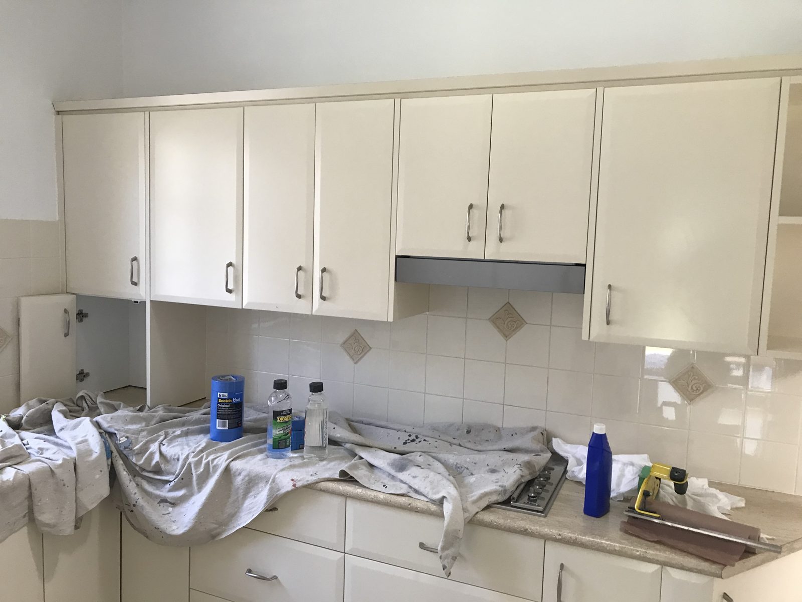 The same kitchen before, mid-preparation with dated cream cabinets
